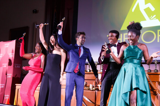 Students Winning Torty on Stage with arms raised